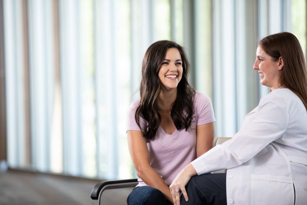 Nurse and Ivy patient sitting and smiling while talking