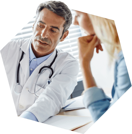 Older male doctor speaking with female
