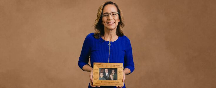 Sobreviviente de cáncer cerebral sosteniendo una foto de su familia