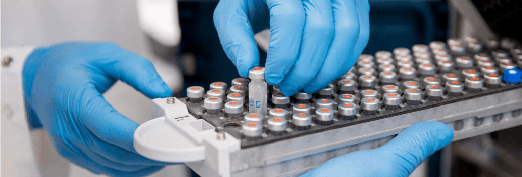 Gloved hands placing specimens in a container