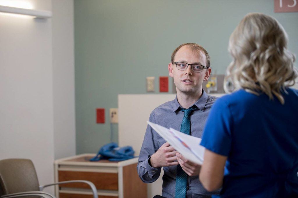 Nick Stump speaking with a nurse in the office