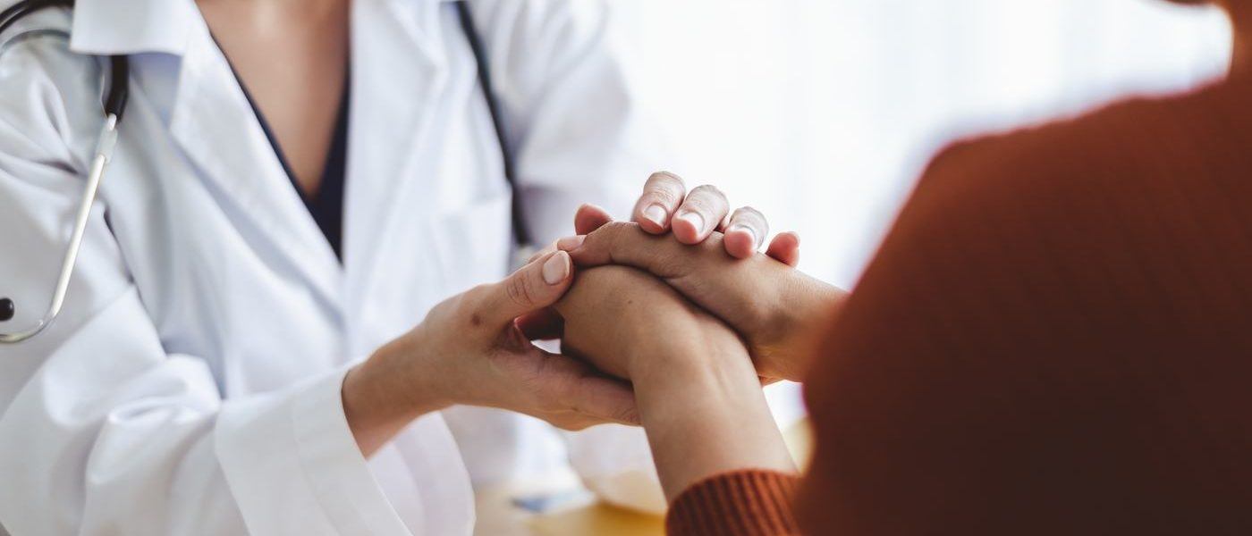 a doctor holding her patients hands