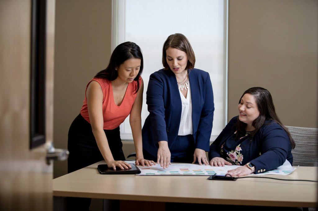 Women explaining information to two people