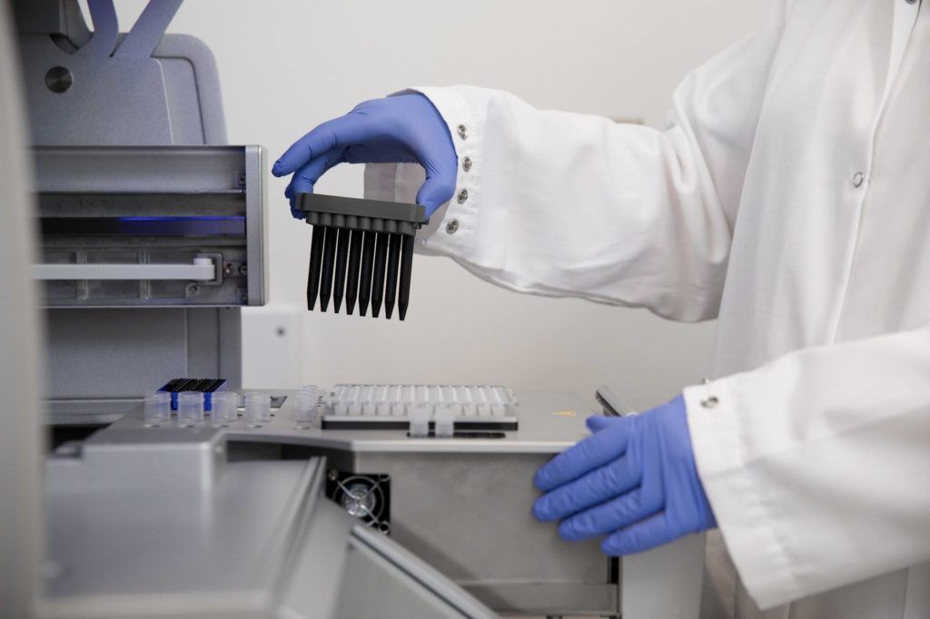 Gloved hands of a lab tech working on a research project