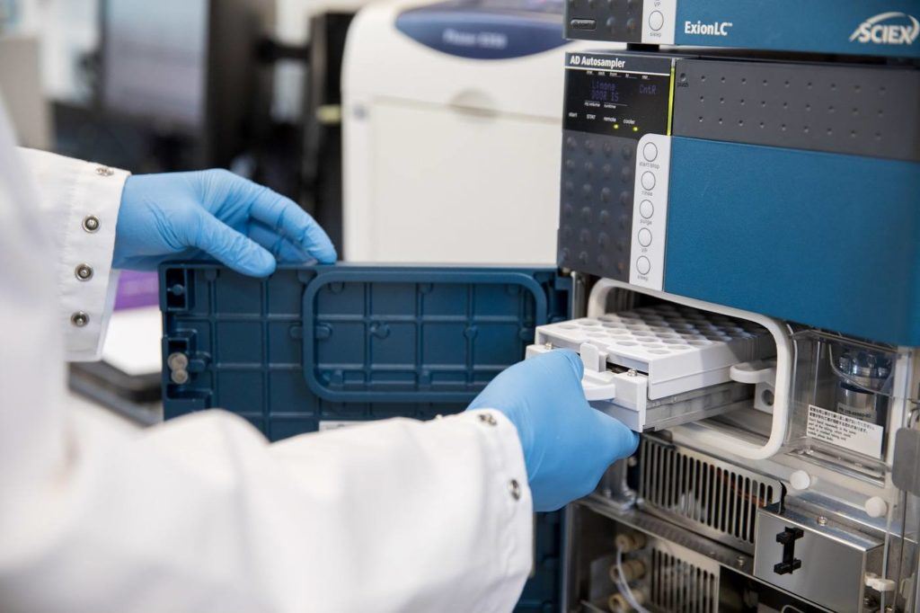 Researcher putting vials in lab equipment