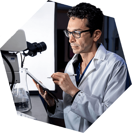 Researcher looking into microscope