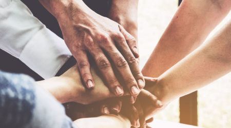 Team stacking hands to show teamwork