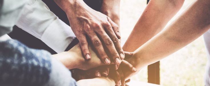 Team stacking hands to show teamwork