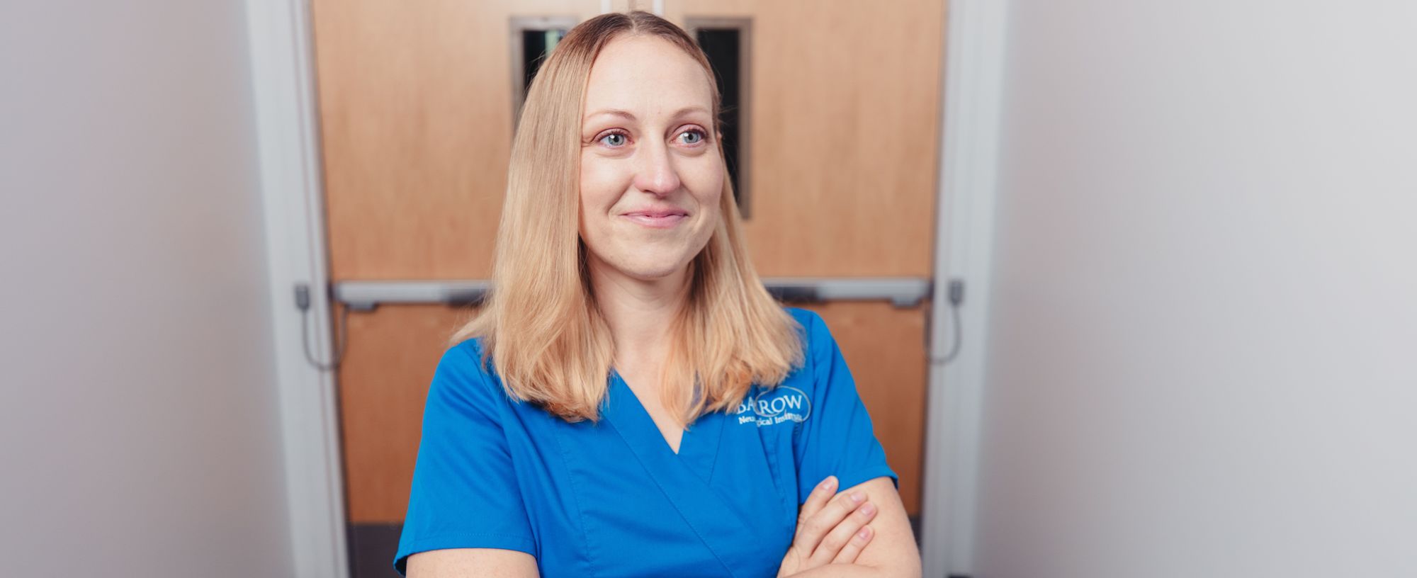 Nurse standing with arms crossed over chest smiling