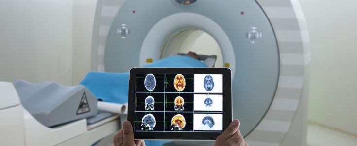 Digital tablet being held in front of MRI machine
