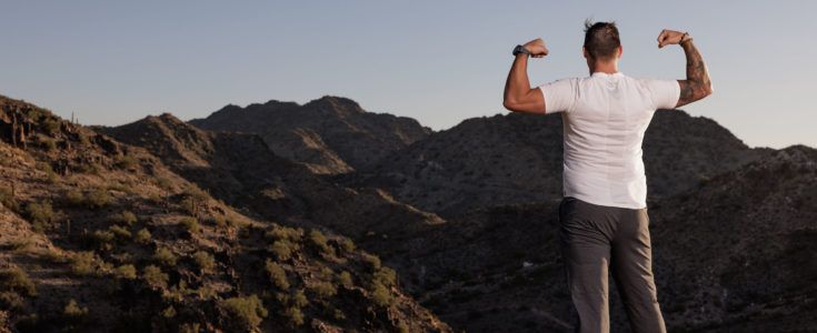 Young man flexing on a mountain