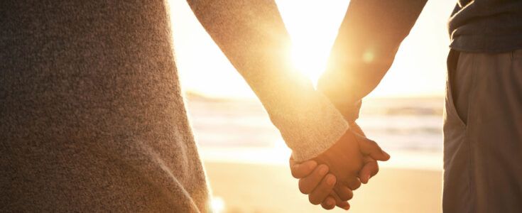 Rearview shot of an unrecognizable couple holding hands while at the beach